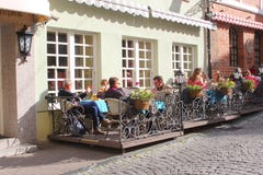 Folket dricker öl och kopplar av på en kaféterrass i den gamla staden av Vilnius, Litauen royaltyfria bilder Folket dricker öl och kopplar av på en kaféterrass i den gamla staden av Vilnius, Litauen royaltyfria bilder