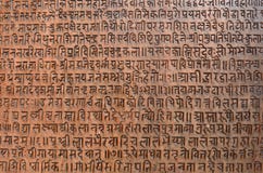 Fond avec le texte sanskrit antique gravé à l'eau-forte dans un comprimé en pierre images stock Fond avec le texte sanskrit antique gravé à l'eau-forte dans un comprimé en pierre images stock