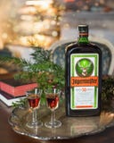 Fond de bonne année ou de Noël avec la boisson d'alcool de Jagermeister, élixir Bouteille de Jagermeister avec des verres sur un images libres de droits Fond de bonne année ou de Noël avec la boisson d'alcool de Jagermeister, élixir Bouteille de Jagermeister avec des verres sur un images libres de droits