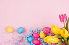 Fond de fête de Pâques de printemps - oeufs multicolores peints faits maison, bouquet de tulipes sur le fond rose-clair en pastel Image stock Fond de fête de Pâques de printemps - oeufs multicolores peints faits maison, bouquet de tulipes sur le fond rose-clair en pastel Image stock