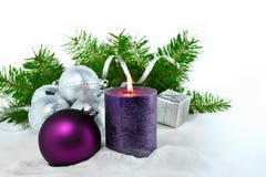 Fond de Noël avec la bougie et les décorations Boules pourpres et argentées de Noël au-dessus des branches d'arbre de sapin dans Photographie stock libre de droits Fond de Noël avec la bougie et les décorations Boules pourpres et argentées de Noël au-dessus des branches d'arbre de sapin dans Photographie stock libre de droits