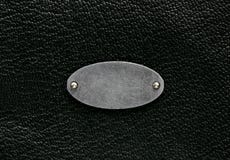 Fond en cuir noir de texture, label en métal Image libre de droits Fond en cuir noir de texture, label en métal Image libre de droits