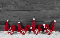 Fond gris en bois de Noël avec les chapeaux et les cadeaux rouges de Santa photo libre de droits Fond gris en bois de Noël avec les chapeaux et les cadeaux rouges de Santa photo libre de droits