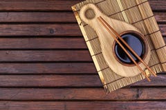 Fond pour des sushi Tapis en bambou, sauce de soja, baguettes sur la table en bois L'espace de vue supérieure et de copie photo stock Fond pour des sushi Tapis en bambou, sauce de soja, baguettes sur la table en bois L'espace de vue supérieure et de copie photo stock
