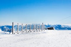 Fond rural d'hiver de vacances avec les pins blancs, barrière, champ de neige, montagnes photo stock Fond rural d'hiver de vacances avec les pins blancs, barrière, champ de neige, montagnes photo stock