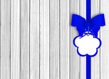 Fondo de madera blanco con el arco azul hermoso con la etiqueta foto de archivo libre de regalías Fondo de madera blanco con el arco azul hermoso con la etiqueta foto de archivo libre de regalías