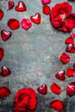 Fondo del vintage con los corazones rojos y los pétalos color de rosa, visión superior, marco Tarjeta del día de tarjetas del día Fotos de archivo Fondo del vintage con los corazones rojos y los pétalos color de rosa, visión superior, marco Tarjeta del día de tarjetas del día Fotos de archivo