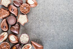 Fondo delicioso clasificado de las almendras garapiñadas del chocolate en la textura gris, lugar para el texto, fotografía del pr foto de archivo libre de regalías Fondo delicioso clasificado de las almendras garapiñadas del chocolate en la textura gris, lugar para el texto, fotografía del pr foto de archivo libre de regalías