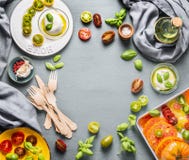 Fondo dell'alimento con i pomodori variopinti, il formaggio della mozzarella con l'olio di olive e le foglie del basilico sul tav fotografia stock Fondo dell'alimento con i pomodori variopinti, il formaggio della mozzarella con l'olio di olive e le foglie del basilico sul tav fotografia stock
