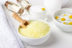 Fondo della stazione termale con il sale del mar Giallo del bagno, la crema naturale e la camomilla fotografia stock Fondo della stazione termale con il sale del mar Giallo del bagno, la crema naturale e la camomilla fotografia stock