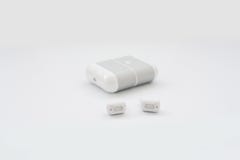 Fones de ouvido sem fio brancos com a caixa de carregamento isolada no fundo branco Nova tecnologia para os corredores: fones de Imagem de Stock Royalty Free Fones de ouvido sem fio brancos com a caixa de carregamento isolada no fundo branco Nova tecnologia para os corredores: fones de Imagem de Stock Royalty Free