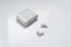 Fones de ouvido sem fio brancos com a caixa de carregamento isolada no fundo branco Nova tecnologia para os corredores: fones de Foto de Stock Royalty Free Fones de ouvido sem fio brancos com a caixa de carregamento isolada no fundo branco Nova tecnologia para os corredores: fones de Foto de Stock Royalty Free
