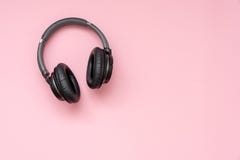 Fones de ouvido sem fio pretos modernos em um fundo cor-de-rosa foto de stock Fones de ouvido sem fio pretos modernos em um fundo cor-de-rosa foto de stock