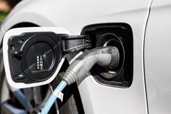 Fonte de alimentação para o carregamento do carro bonde Feche acima da fonte de alimentação obstruída em um soquete do carro elét imagem de stock Fonte de alimentação para o carregamento do carro bonde Feche acima da fonte de alimentação obstruída em um soquete do carro elét imagem de stock