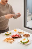 Food photo on the smartphone. Sandwich with poached egg stock image Food photo on the smartphone. Sandwich with poached egg stock image