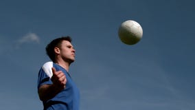 Football player chesting the ball under blue sky