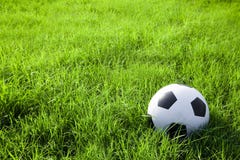Football or soccer ball on the green field