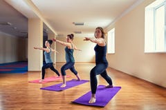 Forma fisica, sport, addestramento, yoga e concetto della gente - donna caucasica che allunga gamba sulla stuoia in palestra Grup fotografia stock libera da diritti Forma fisica, sport, addestramento, yoga e concetto della gente - donna caucasica che allunga gamba sulla stuoia in palestra Grup fotografia stock libera da diritti