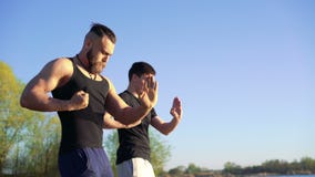Formation de Wing Chun entre le maître et le disciple sur le fond de ciel 4K clips vidéos Formation de Wing Chun entre le maître et le disciple sur le fond de ciel 4K clips vidéos