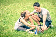 Formation heureuse de couples de forme physique et étirage en parc images stock Formation heureuse de couples de forme physique et étirage en parc images stock