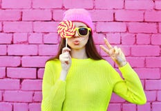 Forme a la muchacha bastante fresca del retrato con la piruleta que se divierte sobre rosa colorido imagen de archivo libre de regalías Forme a la muchacha bastante fresca del retrato con la piruleta que se divierte sobre rosa colorido imagen de archivo libre de regalías