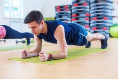 Forme physique formant l'homme sportif sportif faisant l'exercice de planche dans le gymnase ou la classe de yoga exerçant la séa Photo stock Forme physique formant l'homme sportif sportif faisant l'exercice de planche dans le gymnase ou la classe de yoga exerçant la séa Photo stock