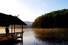 Forêt verte de pin avec le camping du touriste près du lac avec le brouillard au-dessus de l'eau pendant le matin, nort de provin photographie stock Forêt verte de pin avec le camping du touriste près du lac avec le brouillard au-dessus de l'eau pendant le matin, nort de provin photographie stock