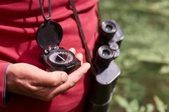Foto anonima della mano dell'uomo con la bussola, viaggiatore su fondo di legno che porta camicia casuale rossa, posante con il b fotografia stock libera da diritti Foto anonima della mano dell'uomo con la bussola, viaggiatore su fondo di legno che porta camicia casuale rossa, posante con il b fotografia stock libera da diritti