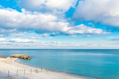 Foto av havet och den molniga himlen På kusten i vattnet är enorma stenar och restna av en konkret struktur arkivfoto Foto av havet och den molniga himlen På kusten i vattnet är enorma stenar och restna av en konkret struktur arkivfoto