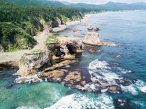 Foto aérea do cabo Ptichiy próximo pelo cabo Velikan, ilha de Sakhalin, Rússia Sahalin Paisagem surrealista, arcos naturais imagens de stock royalty free Foto aérea do cabo Ptichiy próximo pelo cabo Velikan, ilha de Sakhalin, Rússia Sahalin Paisagem surrealista, arcos naturais imagens de stock royalty free