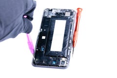 Foto che mostrano il processo di riparazione del telefono cellulare rotto con un cacciavite nel laboratorio per la riparazione di fotografia stock libera da diritti Foto che mostrano il processo di riparazione del telefono cellulare rotto con un cacciavite nel laboratorio per la riparazione di fotografia stock libera da diritti
