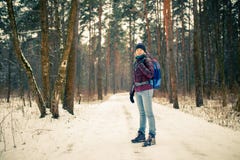 Foto de la mujer sonriente en sombrero con la mochila sobre bosque del invierno imagen de archivo Foto de la mujer sonriente en sombrero con la mochila sobre bosque del invierno imagen de archivo