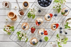 Foto del primo piano dei dolci casalinghi con il formaggio di mascarpone, la cannella, le fragole, i mirtilli ed il bello floweri Immagini Stock Libere da Diritti Foto del primo piano dei dolci casalinghi con il formaggio di mascarpone, la cannella, le fragole, i mirtilli ed il bello floweri Immagini Stock Libere da Diritti