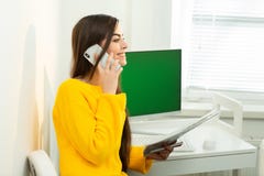 Foto della donna, parlante sul telefono e leggente i documenti in ufficio Schermo verde nei precedenti fotografia stock Foto della donna, parlante sul telefono e leggente i documenti in ufficio Schermo verde nei precedenti fotografia stock