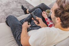 Foto di giovani coppie felici felici che si siedono su uno strato all'interno e sulla TV di sorveglianza Lo sguardo lateralmente fotografia stock libera da diritti Foto di giovani coppie felici felici che si siedono su uno strato all'interno e sulla TV di sorveglianza Lo sguardo lateralmente fotografia stock libera da diritti