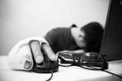 Foto di un uomo con le lesioni che provano a lavorare al suo computer fotografia stock Foto di un uomo con le lesioni che provano a lavorare al suo computer fotografia stock
