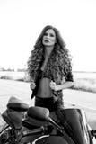 Foto preto e branco de uma menina bonita do motociclista com uma motocicleta fotografia de stock Foto preto e branco de uma menina bonita do motociclista com uma motocicleta fotografia de stock
