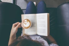 Foto suave de la chica joven que lee un libro y que bebe el café, top fotos de archivo libres de regalías Foto suave de la chica joven que lee un libro y que bebe el café, top fotos de archivo libres de regalías