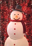 Foto vertical de um boneco de neve grande na frente dos pinheiros vermelhos artificiais da efervescência para a decoração interna foto de stock Foto vertical de um boneco de neve grande na frente dos pinheiros vermelhos artificiais da efervescência para a decoração interna foto de stock