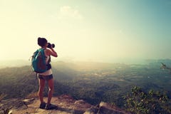 Fotógrafo de la mujer que toma la foto en el pico de montaña imagenes de archivo Fotógrafo de la mujer que toma la foto en el pico de montaña imagenes de archivo