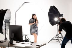 Fotógrafo e modelo bonito que trabalham no estúdio moderno da iluminação fotografia de stock Fotógrafo e modelo bonito que trabalham no estúdio moderno da iluminação fotografia de stock