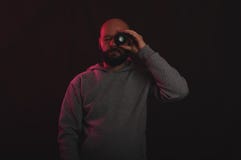 Fotógrafo que mira a través de la lente de la foto en estudio con el vintage o la iluminación retra fotografía de archivo libre de regalías Fotógrafo que mira a través de la lente de la foto en estudio con el vintage o la iluminación retra fotografía de archivo libre de regalías