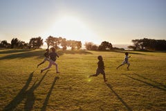 Four elementary school children running in an open field stock photos Four elementary school children running in an open field stock photos