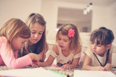 Four girls lying on the floor. Four girls lying on the floor and write their homework. Close up Stock Photos Four girls lying on the floor. Four girls lying on the floor and write their homework. Close up Stock Photos