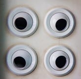 Four white air vent and sound outlet on white airport wall in different directions stock photo Four white air vent and sound outlet on white airport wall in different directions stock photo