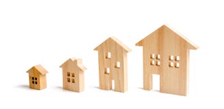 four wooden houses stand in ascending order on a white background. Isolate The concept of increasing population density stock photos four wooden houses stand in ascending order on a white background. Isolate The concept of increasing population density stock photos