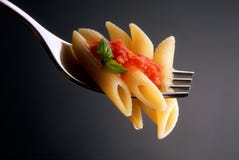 Fourchette avec les pâtes et le basilic de tomate photo libre de droits Fourchette avec les pâtes et le basilic de tomate photo libre de droits