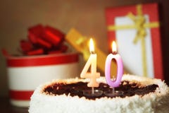 Fourty years birthday. Cake with burning candles and gifts Stock Image Fourty years birthday. Cake with burning candles and gifts Stock Image