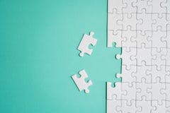 Fragment d'un puzzle denteux blanc plié et une pile des éléments mal peignés de puzzle dans la perspective d'une surface colorée photos libres de droits Fragment d'un puzzle denteux blanc plié et une pile des éléments mal peignés de puzzle dans la perspective d'une surface colorée photos libres de droits
