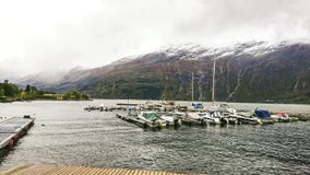 Fragment of the pier in Surfjorden near the city of Odda, Norway. View of the large mountain plateau with its massive glaciers. royalty free stock photos Fragment of the pier in Surfjorden near the city of Odda, Norway. View of the large mountain plateau with its massive glaciers. royalty free stock photos